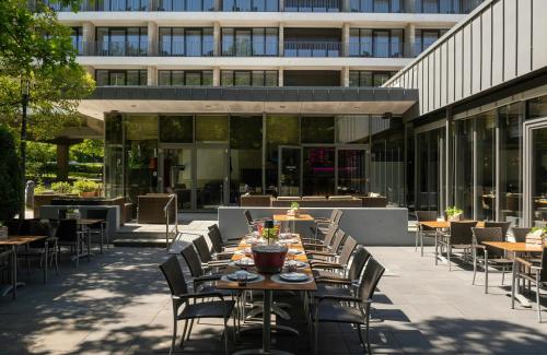 a group of tables and chairs on a patio at Leonardo Hotel Hannover in Hannover