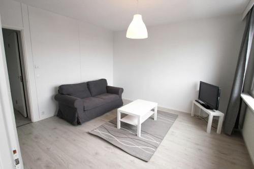 a living room with a couch and a tv at Central Apartment for 2 in Mikkeli
