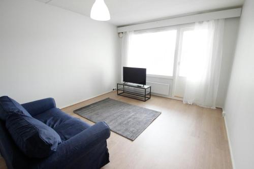 a living room with a blue couch and a television at Spacious Apartment for 2 in Mikkeli