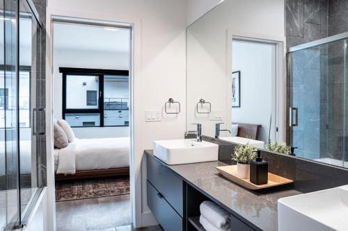 a bathroom with a sink and a mirror and a bedroom at The Begbie Penthouse in Mackenzie Village in Revelstoke