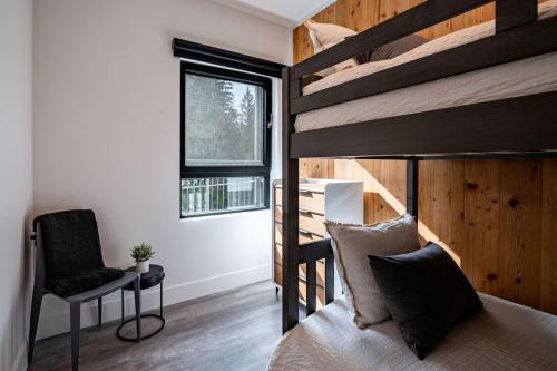 a bedroom with a bunk bed and a desk and a chair at The Begbie Penthouse in Mackenzie Village in Revelstoke