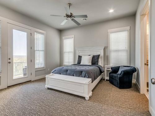 a bedroom with a bed and a fan and windows at Shore Enough, Carlton Landing, Lakeview for 12 in Carlton Landing