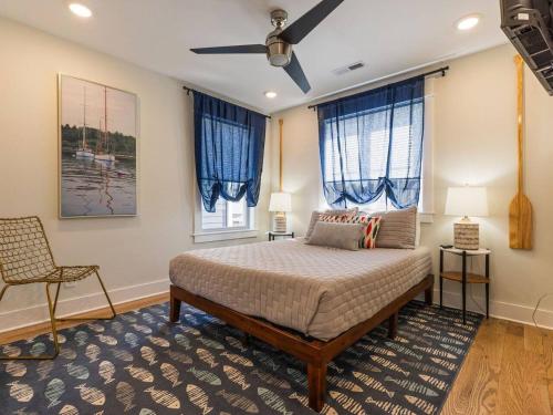 een slaapkamer met een bed, een stoel en ramen bij Barefoot Dreams in Winchester