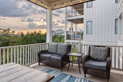 a porch with two chairs and a table with a view at Shore Enough, Carlton Landing, Lakeview for 12 in Carlton Landing