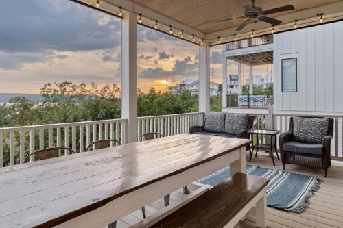 a porch with a wooden table and chairs at Shore Enough, Carlton Landing, Lakeview for 12 in Carlton Landing