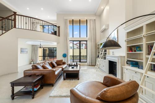 a living room with two couches and a fireplace at Luxe Villa Spacious Family Home with Pool and Patio in Brisbane