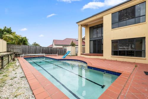 a swimming pool in front of a house at Luxe Villa Spacious Family Home with Pool and Patio in Brisbane