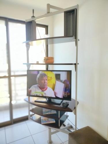 a book shelf with a tv on top of it at Ocean Atlantic Praia de Iracema in Fortaleza