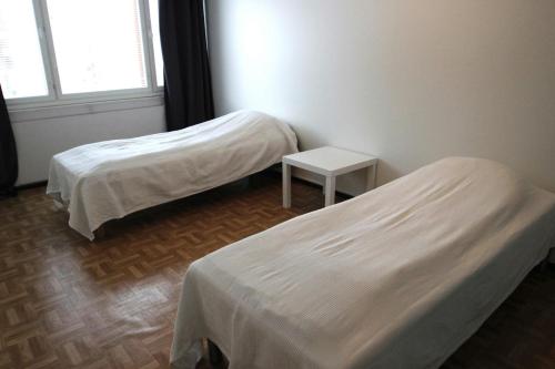 a room with two beds and a table and a window at Spacious Apartment for 6 in Mikkeli
