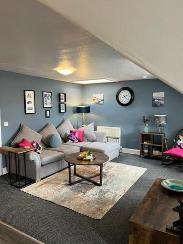 a living room with a couch and a table at Caledonian House Apartment in Fort William