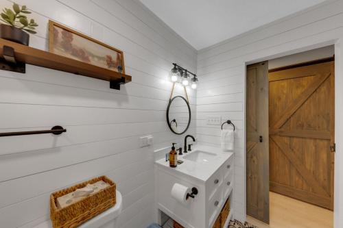 a white bathroom with a sink and a mirror at The White Lodge 4BDR Sleeps 8 with Fire Pit in Alcoa
