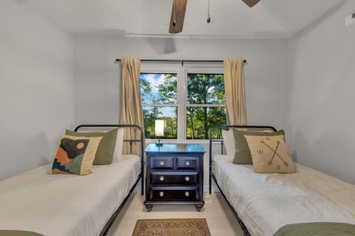 two beds in a room with a window at The White Lodge 4BDR Sleeps 8 with Fire Pit in Alcoa
