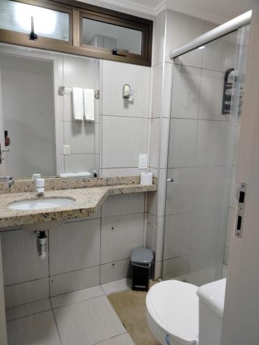 a bathroom with a toilet and a sink and a shower at Ocean Atlantic Praia de Iracema in Fortaleza