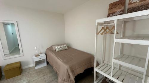 a small bedroom with a bed and a mirror at Departamentos Caranday in San Luis