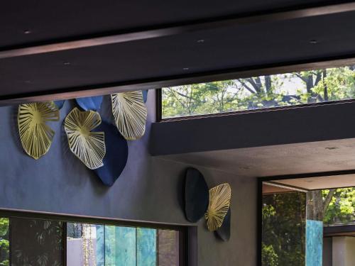 a group of pans hanging on a wall next to windows at Vivari Hotel and Spa by Mantis in Johannesburg