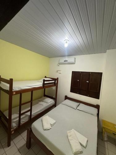 a room with two bunk beds and a bench at Hostel Caribe Maragogi in Maragogi