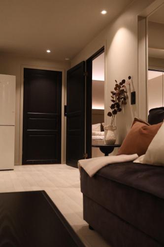 a bedroom with a black door and a couch at Arctic City Suites 2 in Kirkenes