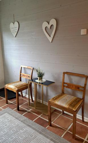 a table and two chairs and hearts on the wall at Beautiful and cosy house near the lake in Olofström