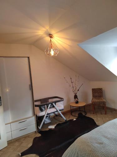 een kamer met een bed, een tafel en een plafond bij Maison mignonne in Hirson