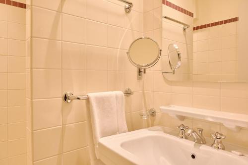 a white bathroom with a sink and a mirror at Hôtel Le Provençal - Rénové en 2025 - Bord de Mer in Hyères