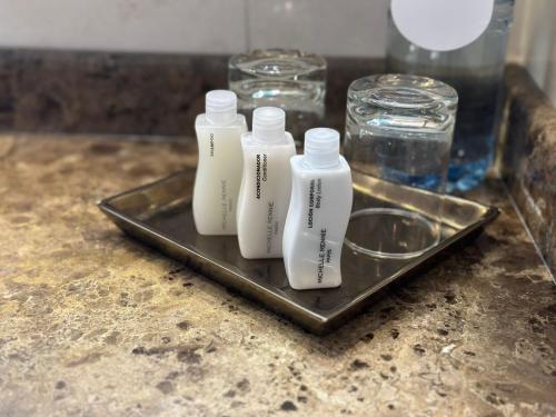 three white bottles sitting on a tray on a counter at Regal Pacific Puerto Madero in Buenos Aires