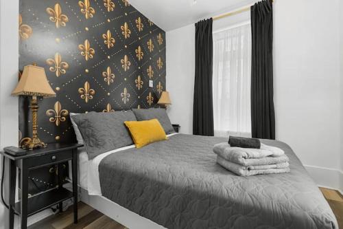 1 dormitorio con 1 cama con una pared negra y dorada en Suite Jardin, en Quebec
