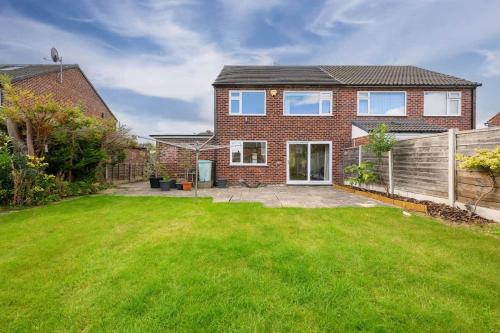 a brick house with a green yard at City SuperHost Lovely 3 bed Wythenshawe Home in Wythenshawe
