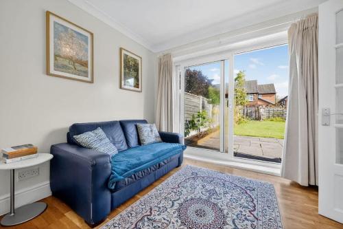 a living room with a blue couch and a large window at City SuperHost Lovely 3 bed Wythenshawe Home in Wythenshawe
