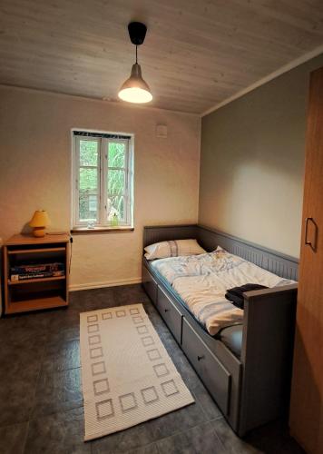 a bedroom with a bed and a window at Beautiful and cosy house near the lake in Olofström