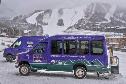 two blue trucks parked in the snow with a mountain at Fuerza Grande in Steamboat Springs
