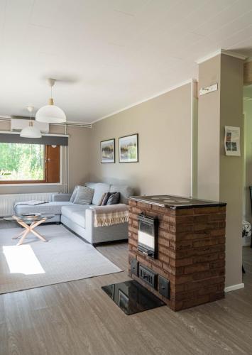 a living room with a couch and a fireplace at Ranua Haistila Retreat with Elegant Views & Sauna near Rovaniemi in Ranua