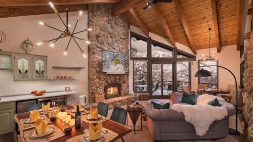 a living room with a table and a fireplace at Glacier Grande in Steamboat Springs