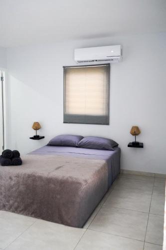 a bedroom with a bed with two lamps and a window at Beach House, Tranquil Santirome Studio 1 in Westpunt