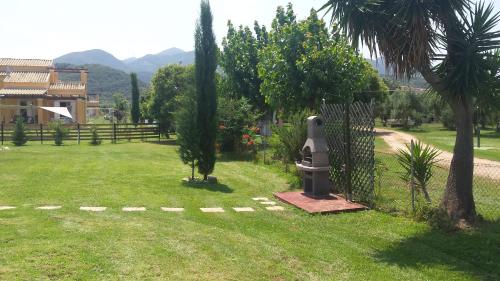 a garden with a fence and trees and a house at Villa Filia in Almiros Beach