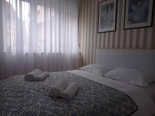 a bedroom with a bed with two towels on it at Central Residence Banja Luka Spacious Apartment with Private Parking in Banja Luka