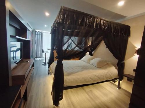 a bedroom with a canopy bed with white sheets at Romántica Suite entre tules in Arequipa