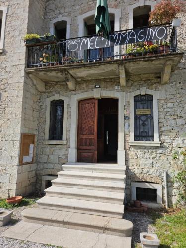 a stone building with a wooden door and a balcony at La casa di Mel in Mel