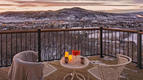 a table and chairs on a balcony with a view at Glacier Lodge - West in Steamboat Springs