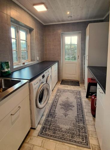 a kitchen with a washer and dryer in a room at Beautiful and cosy house near the lake in Olofström