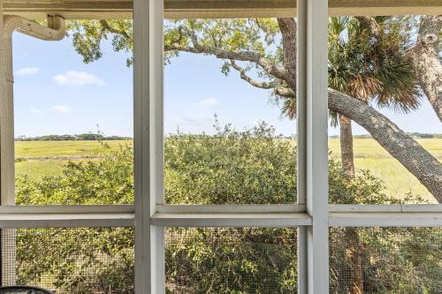 a window view of a tree and a field at 1806 Heron Point in Summerville