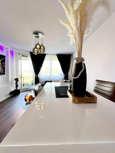 a living room with a large white table with a vase at Travemünde Ruheoase mit Pool Sauna Parkplatz in Rönnau