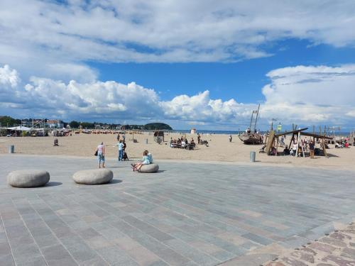a group of people standing on a beach with a sandy beach at Travemünde Ruheoase mit Pool Sauna Parkplatz in Rönnau