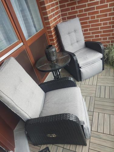 two chairs and a table and a chair on a patio at Travemünde Ruheoase mit Pool Sauna Parkplatz in Rönnau