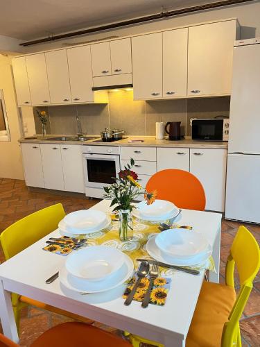 a kitchen with a table with plates and flowers on it at Apartments Bukor with seasonal pool in Lukovica pri Domžalah