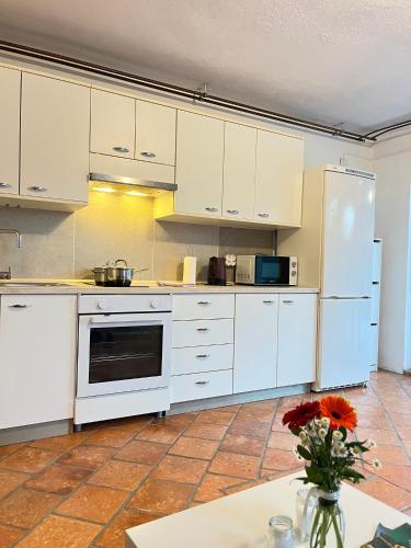 a kitchen with white cabinets and a white refrigerator at Apartments Bukor with seasonal pool in Lukovica pri Domžalah