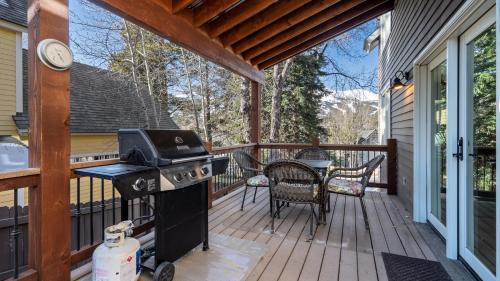 een veranda met een grill en een tafel en stoelen bij Great Raven Grande in Breckenridge