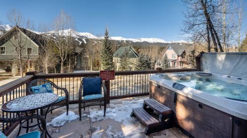 een hot tub op een terras met een tafel en stoelen bij Great Raven Grande in Breckenridge