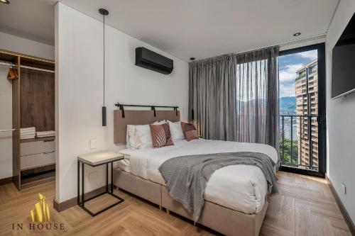 une chambre avec un lit et une grande fenêtre dans l'établissement Morph 1002 - Luxe apt in Poblado/AC/BBQ, à El Poblado