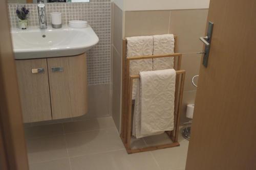 a bathroom with a sink and a towel rack at Cabanas Apartment in Tavira