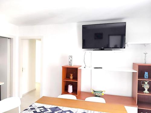 a living room with a flat screen tv on a wall at Paradise Home just a few minutes from Lake Maggiore in Gravellona Toce